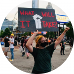 protester with sign reading "what will it take"