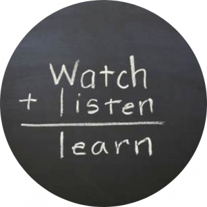 chalkboard reading "watch + listen = learn"