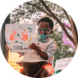 black boy wearing sunglasses and mask holding finger painting with hands and reads "RESPECT on my LIFE"