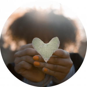 heart-shaped leaf held by black woman hands