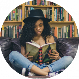 black teen girl crosslegged on couch reading